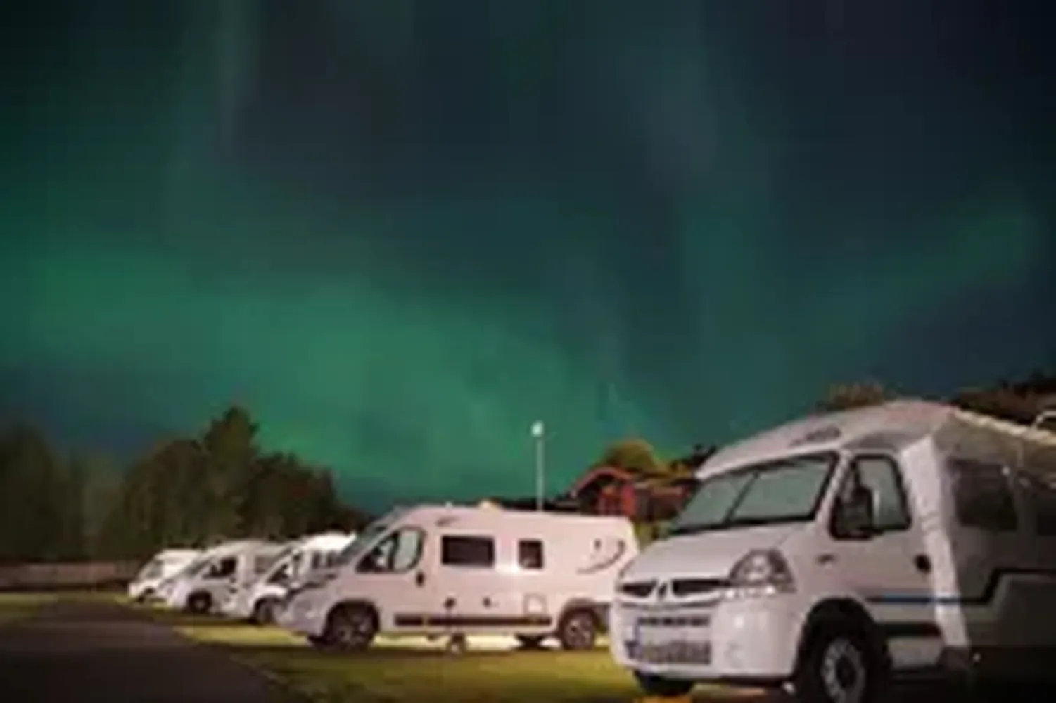 Campingplass i Lillehammer med bobiler under nordlyset. Perfekt for en avslappende ferie nær naturen med moderne fasiliteter og flott utsikt.